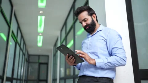Smiling young indian businessman using digital tablet at office. Corporate .. Stock Footage 292951650