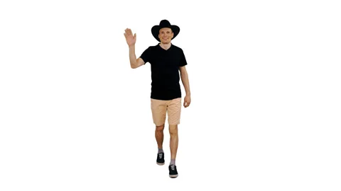 Smiling young man in black T-shirt walks and waving greetings, alpha channel Stock-Footage 90051473