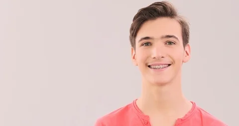 Smiling young man with braces on his teeth. Handsome young boy with even heal Stock Footage 126907827