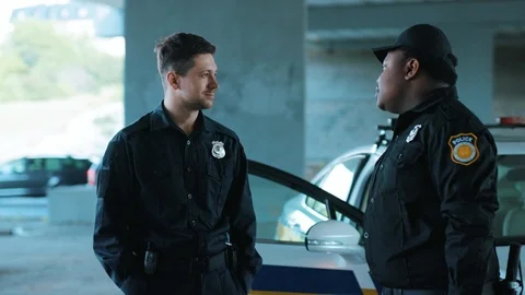 Smiling young man cops stand near patrol car look at camera enforcement officer Stock Footage 113002134