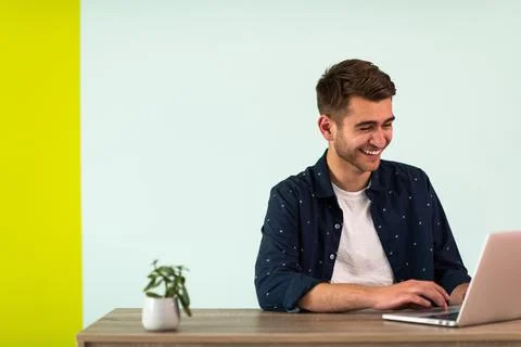 Smiling young man freelancer using laptop studying online working from home Foto stock