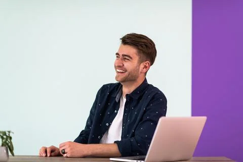 Smiling young man freelancer using laptop studying online working from home Stockfoto's
