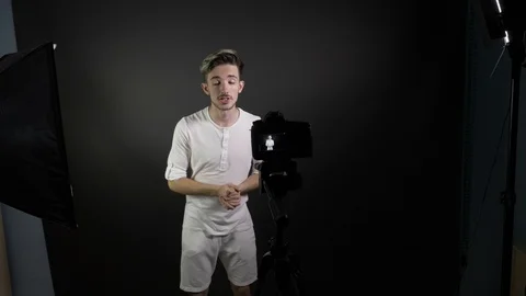 Smiling young man geturing while recording a video for his vlog in a professi Stock Footage 86137915