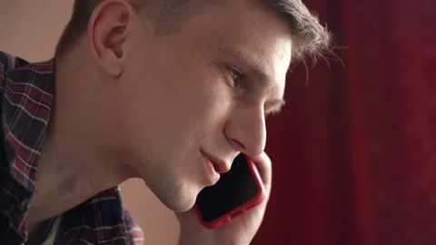 Smiling young man having a discussion on a mobile phone. Stock Footage 210552454
