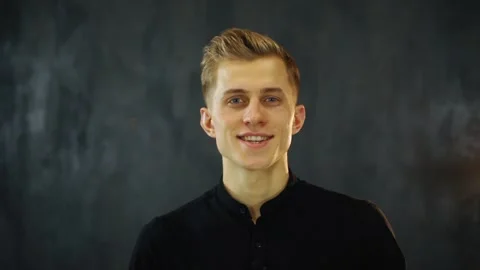 Smiling young man look at camera and recording vlog in loft studio Stock Footage 131550485