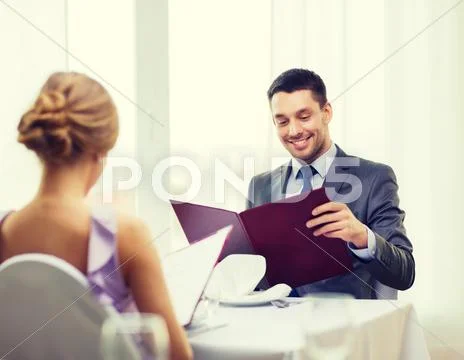 Smiling young man looking at menu at restaurant Stock Photos