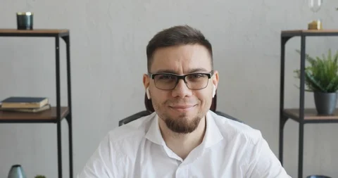 Smiling young man office worker in glasses sitting at table looking at camera. Stock Footage 120835823