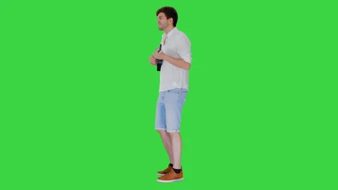 Smiling young man playing ukulele looking into the camera on a Green Screen Stock Footage 140890097
