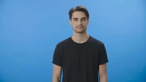 Smiling, young man pointing at corners with blank spaces 4K Stock Footage 88399383