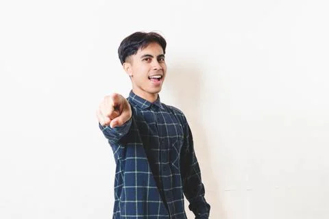 Smiling young man pointing directly at the camera, creating a confident and.. Stock Photos