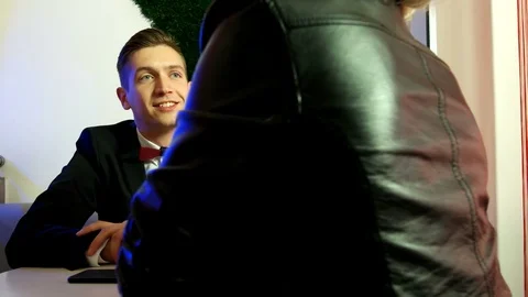 Smiling young man talking to his friend in a cafe Stock Footage 75810194