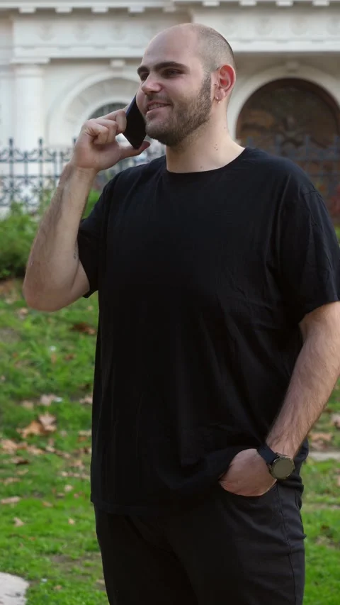 Smiling young man talking on the phone at the park Stock Footage 289002902
