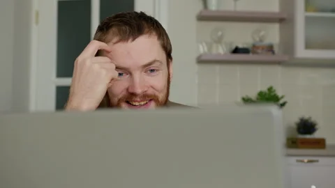 Smiling young man talking while working on laptop. Stock Footage 262949310