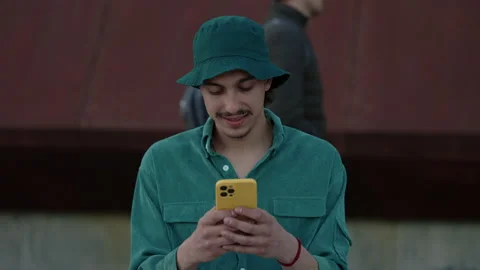 Smiling young man using cell phone on city street Stock Footage 162741271