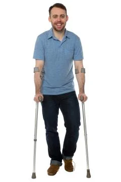 Smiling young man using crutches Stock Photos