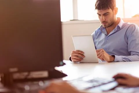 Smiling young man using digital tablet in the office Foto stock