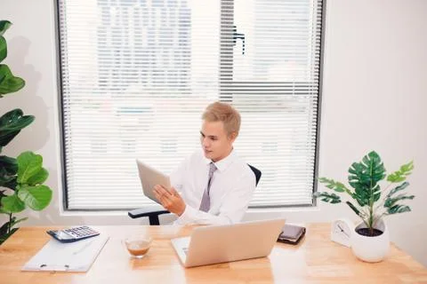 Smiling young man using digital tablet in the office Stock Photos