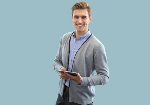 Smiling young man using digital tablet on blue background Stock Photos