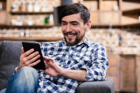 Smiling young man using his tablet Stock Photos