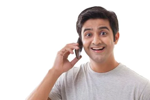 Smiling young man using mobile phone over white background Stock Photos