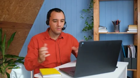 Smiling young man wear headset elearning study with online tutor teacher talk Stock Footage 148228260
