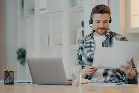Smiling young man working with documents at home Stock Photos
