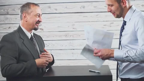 Smiling young manager persuades a client to sign a contract. Видео 142748438