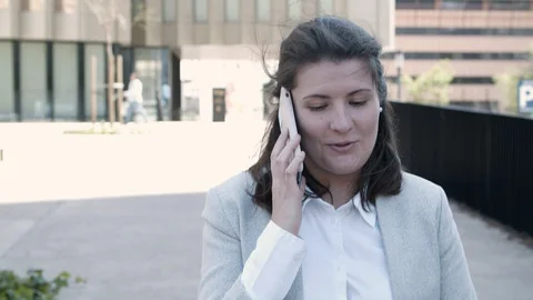 Smiling young manager talking on smartphone during stroll Video stock 127709354