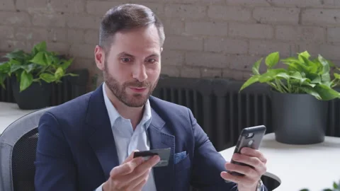 Smiling young middle-eastern man customer holding credit card at laptop sitting Stock Footage 136543094