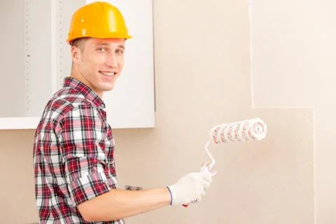 Smiling young painter with a roller Stock Photos