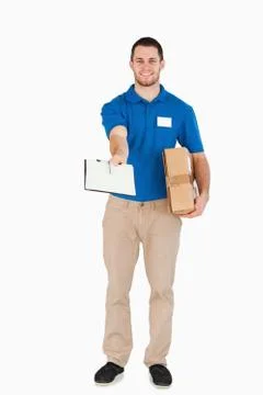Smiling young salesman with parcel asking for signature Stock Photos