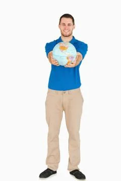 Smiling young salesman presenting globe in his hands Stock Photos
