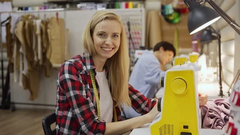 Smiling young seamstress posing at work Stock Footage 125451200