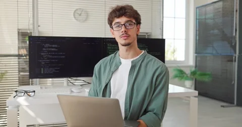 Smiling Young Software Developer Working on Laptop in Bright Modern Office Video stock 345679996