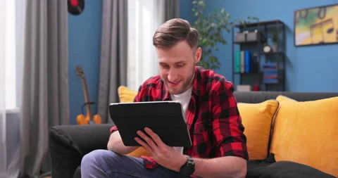 Smiling young student man using digital tablet at home, millennial male user Vídeo Stock 154052347
