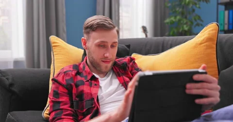 Smiling young student man using digital tablet at home, millennial male user 스톡 동영상 154053868