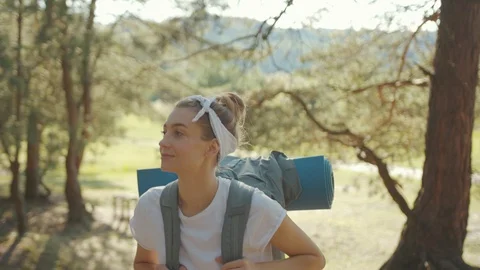 Smiling young tourist with backpack walking in the fall forest on sunny summer Stock Footage 115199017