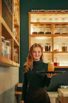 Smiling young waitress serving drinks in a trendy bar Stock Photos