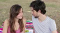smiling young woman and man drinking red wine and kissing in the park HD Footage