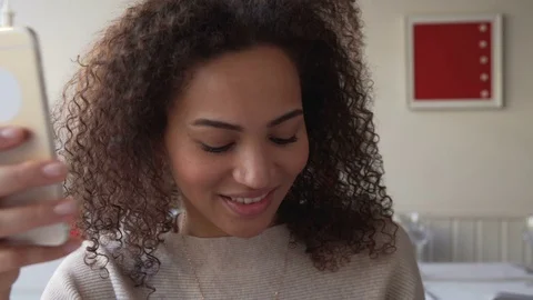 Smiling young woman chatting using mobile phone. May depict third Party IP Stock Footage 72644606