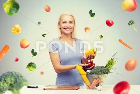 Smiling young woman cooking vegetables at home Stock Photos