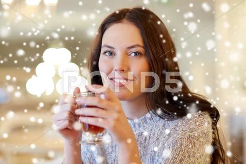 Smiling young woman drinking tea at cafe Stock Photos