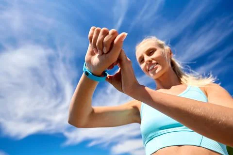 Smiling young woman with fitness tracker outdoors Stock Photos