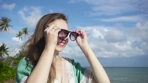 Smiling Young Woman Puts on Sunglasses. Slow Motion Stock Footage 59158461