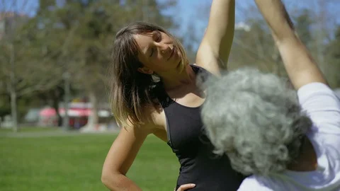 Smiling young woman training with elderly lady in park. Stock Footage 105785341