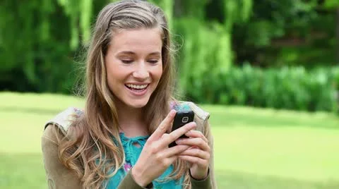 Smiling young woman typing on her cellphone Stock Footage