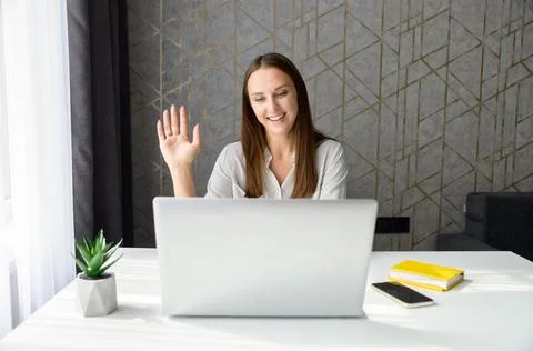 Smiling young woman using computer app for video connection Stock Photos