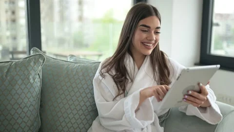 Smiling young woman using digital tablet at home Video stock 152536600