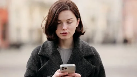 Smiling young woman using smart phone on street. Attractive young blonde Woman Stock Footage 153663021