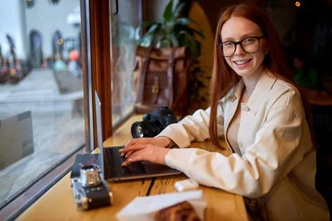 Smiling young woman watching tutorial online on modern laptop device Stock Photos